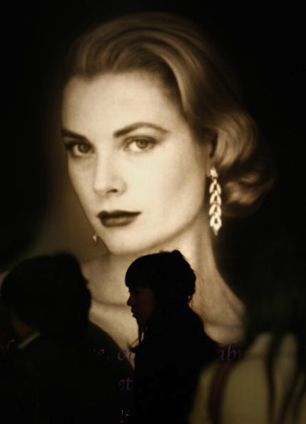 Japanese women walk past a portrait of P